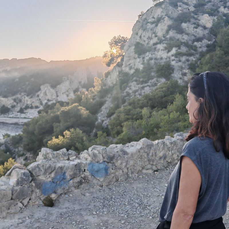Une marcheuse sur le sentier des douaniers au soleil couchant
